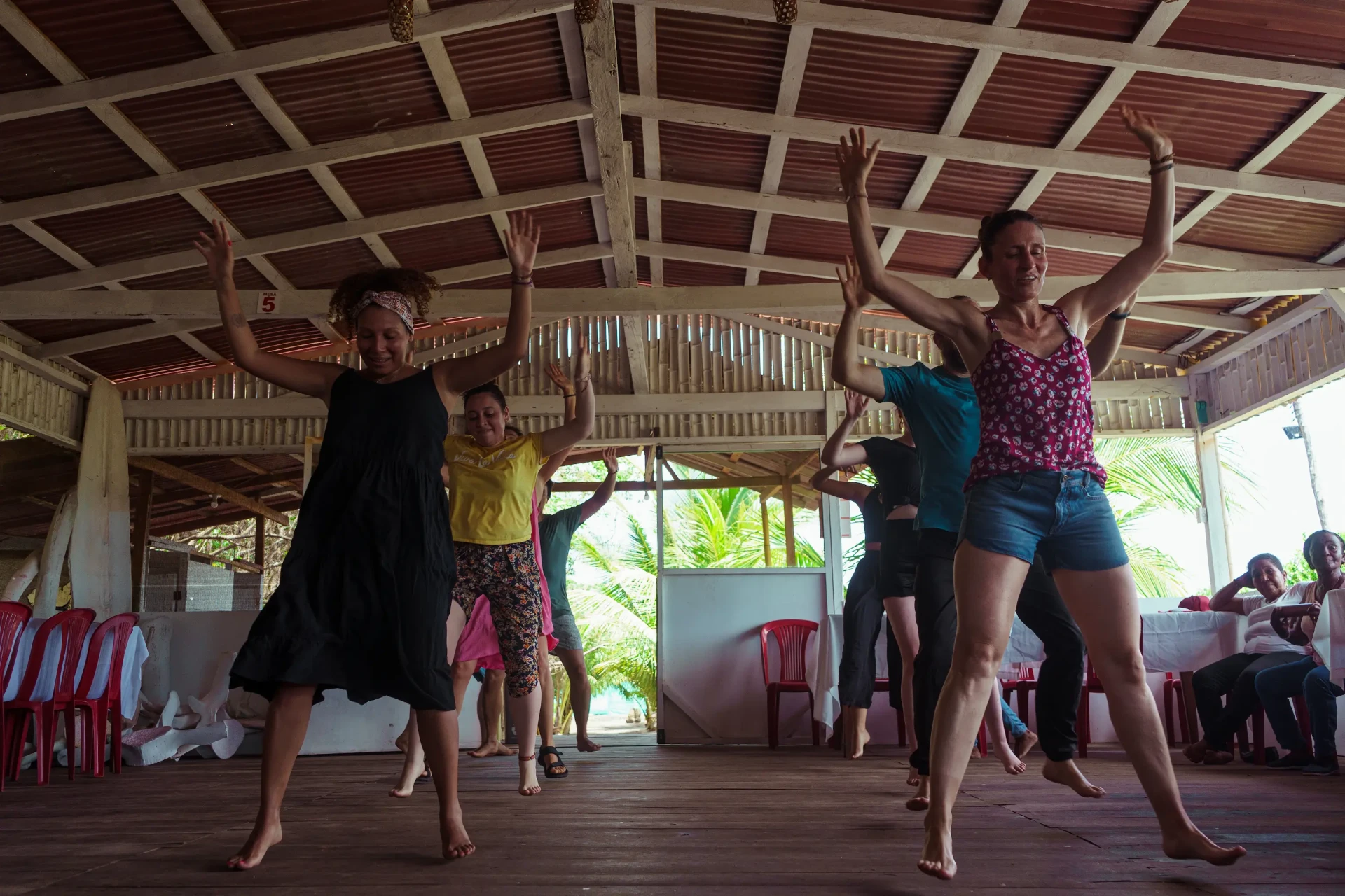 Taller de danza en Tumaco con participantes levantando los brazos