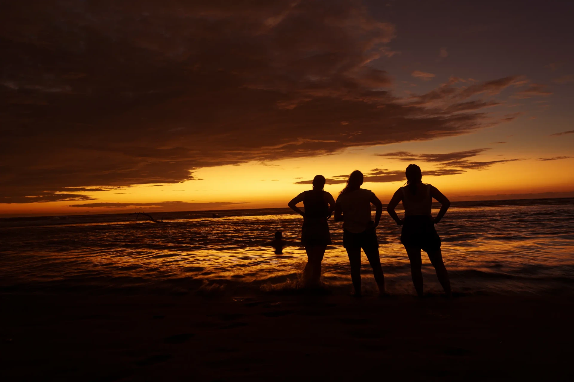 Atardecer en la playa de Tumaco con tres siluetas
