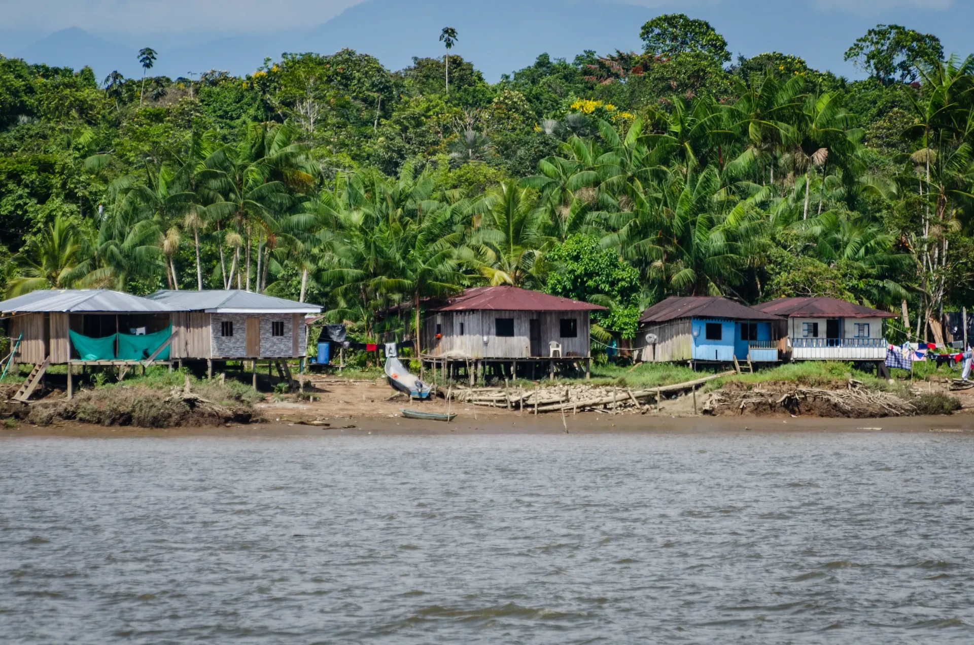 Casas de la comunidad a orillas del río Guapi rodeadas por bosque tropical